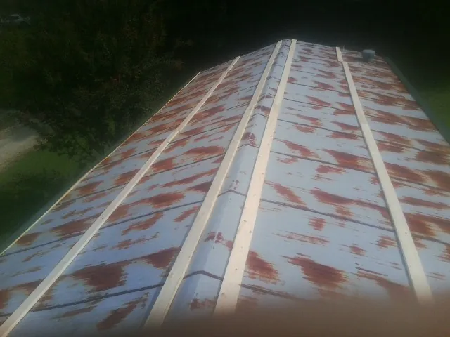 Rusted metal roof panels with new wood purlins before replacement — Storm Damage Roof Repair in Chapin by Roofing Brothers